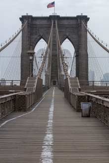 The Brooklyn Bridge's elevated promenade with the pedestrians on the right and cyclists on the left