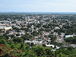 2006 में पोंस शहर का आंशिक दृश्य, जैसा कि सेरो डेल विगिया से देखा गया, पृष्ठभूमि में कैरेबियन सागर और काजा डे मुर्टोस के साथ