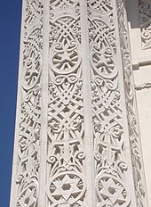A white column with ornate designs carved into it, including a Star of David