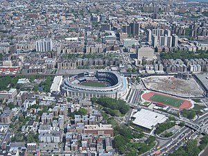 Yankee Stadium (centro), Bronx County Courthouse e o Grand Concourse em direção ao topo. À direita do atual estádio está o local de seu antecessor.