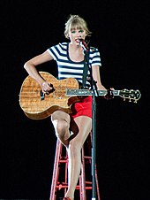 Taylor Swift performing on a guitar