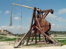 A tall wooden structure with a throwing arm counterbalanced by a large weight