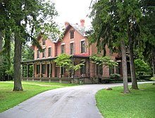 A large brick house surrounded by trees