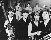 Paul McCartney, George Harrison, Swedish pop singer Lill-Babs and John Lennon on the set of the Swedish television show Drop-In in 1963