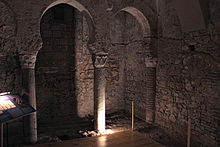 A brick—lined room with two curved brick arches supported on round stone pillars
