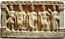 stone statue group, a Buddhist triad depicting, left to right, a Kushan, the future buddha Maitreya, Gautama Buddha, the bodhisattva Avalokiteśvara, and a Buddhist monk. 2nd–3rd century. Guimet Museum
