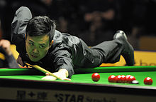 Photograph of Fu taking a shot at the 2013 German Masters