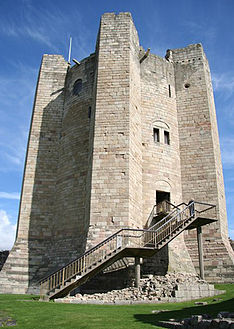 A circular castle tower with enormous jutting buttresses. There are few windows and entrance is on an upper floor, is reached by a modern staircase.