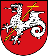 The arms of Roetgen, based on the old arms of Rott, and show the symbol of St. Quirinus, the patron saint of Rott, who, according to the legend, killed a dragon with a crossed-spear