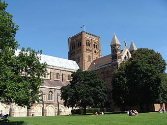 A long, low cathedral has a fine Norman brick crossing-tower rising in three stages of round-topped paired windows. The rest of the building is a conglomeration of styles in ancient brick, modern brick, ashlar and flint.