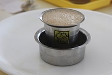 Café servido en un vaso de metal