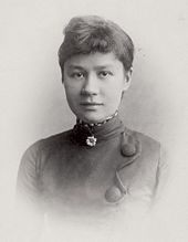 Black and white formal head shot photo of a young woman, with an easy expression and slight smile