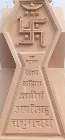 Tan stone relief of the Jain swastika and its five vows