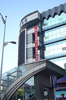 A vertical, red banner hanging high on a building with Chinese writing: "维护法律尊严，严惩犯罪分子"