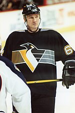 Photograph of Mario Lemieux on the ice holding a hockey stick