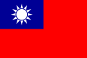 Một lá cờ màu đỏ, có hình chữ nhật nhỏ màu xanh lam ở góc trên cùng bên trái, trên đó có hình mặt trời trắng gồm một vòng tròn được bao quanh bởi 12 tia sáng.