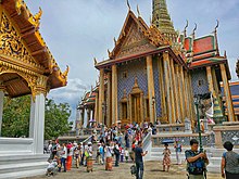 A Thai temple complex with several ornate buildings, and a lot of visitors