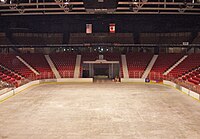 An empty arena with the sheet of ice and the score board
