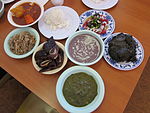 Clockwise from bottom: squid luau, pipikaula shortribs, kalua pig, tripe stew, rice, opihi poke, laulau, and poi in the center