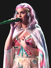 Katy Perry performing in a pink cloak, during the Prismatic World Tour