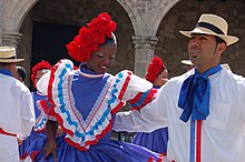 A man and woman in colorful dress dancing