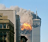 The twin towers are seen spewing black smoke and flames, particularly from the left of the two.