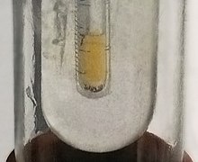 Pequeña muestra de flúor líquido amarillo pálido condensado en nitrógeno líquido