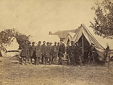 Lincoln among a group of soldiers in a military camp