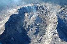 Summit crater with lava domes in center and rocky glaciers growing on the side