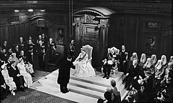 Queen Elizabeth II opening a session of the New Zealand Parliament on 12 January 1954 in the Legislative Council Chamber, Parliament House. She is accepting a vellum copy of her speech from the throne from Sir Sidney Holland (Prime Minister, 1949-1957).