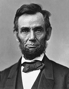 수염을 기른 ​​에이브 러햄 링컨의 머리와 어깨를 보여주는 상징적 인 사진.