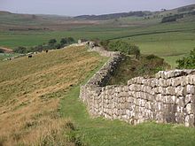 A stone wall winding over a hilly landscape