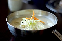 A wheat noodles with a cold white broth in a stainless bowl
