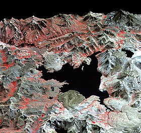 Una imagen de satélite en falso color de la Laguna del Maule, un lago de forma irregular dentro de las montañas