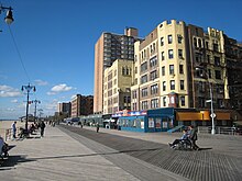 The Brighton Beach extension of the Riegelmann Boardwalk, adjacent to brick apartment buildings on the right