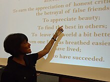 Woman pointing to a Power Point presentation.