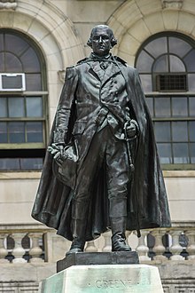 A nearly black bronze statue General Nathanael Greene in uniform, stepping forward with a hand on his sword