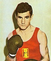 A headshot of a boxer wearing a red vest.