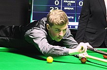 Picture of James Cahill playing snooker.