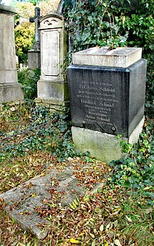 A cubic tombstone inscribed with the names Anna Schmid, Friedrich Schmid and Anna Schmid