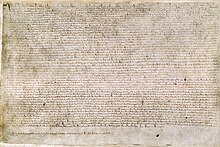 A photograph of a page of Magna Carta, a wide page of dense, small medieval writing.