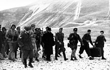 line of German soldiers walking with Mussolini
