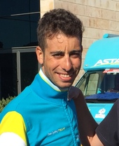 A photograph of Fabio Aru in front of an Astana team vehicle
