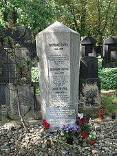 A tapering six-sided stone structure lists the names of three deceased persons: Franz, Hermann, and Julie Kafka. Each name has a passage in Hebrew below it.