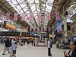 Victoria station concourse. British flags hang from the ceiling.