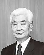 upper-body shot of older man with white hair, dark suit and tie
