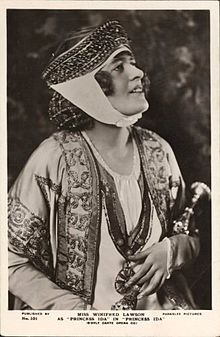 Young white woman in vaguely mediaeval costume with elaborate headgear
