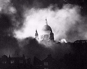 Black and White photograph of the dome of St Paul's, starkly lit, appearing through billowing clouds of smoke