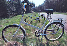A white bicycle parked in the grass.